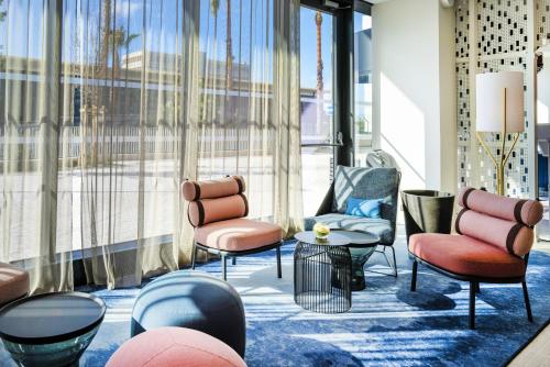 a lobby with chairs and tables and a large window at Crowne Plaza - Nice - Grand Arenas by IHG in Nice