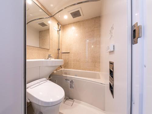 La salle de bains est pourvue de toilettes, d'un lavabo et d'une baignoire. dans l'établissement APA Hotel Shin Osaka-Eki Tower, à Osaka