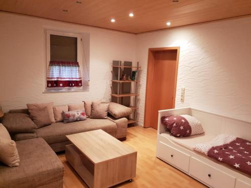 a living room with a couch and a table at Sunshine Westernranch in Kasendorf