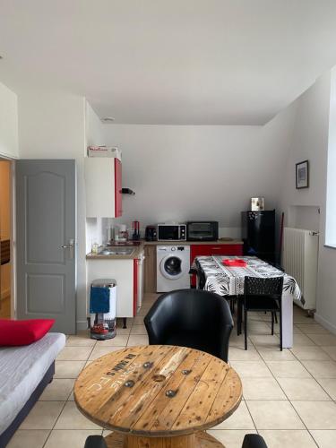 un salon avec une table et une cuisine dans l'établissement La bourboule Appartement, à La Bourboule