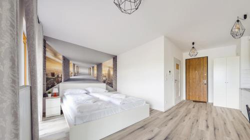 a white bedroom with two beds and a hallway at Apartamenty Sun & Snow Nadmotławie z sauną in Gdańsk