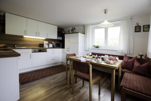 una cucina e una sala da pranzo con tavolo e sedie di Ferienhaus Troy a Doren