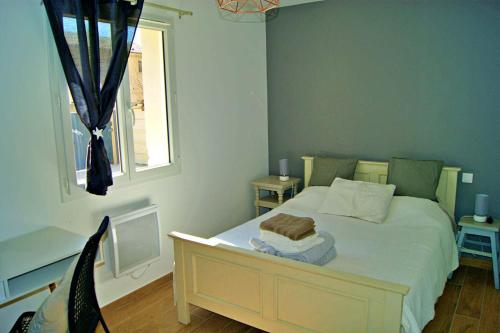 une chambre avec un lit blanc avec une fenêtre dans l'établissement La Petite Maison en Provence, à Saint-Rémy-de-Provence