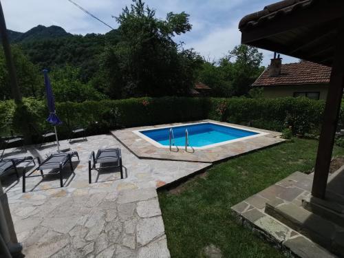uma piscina com cadeiras ao lado de um quintal em Villa Nanevi em Teteven