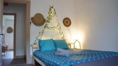 1 dormitorio con 1 cama con un árbol de Navidad en la pared en L'appart & de la Turdine à L'arbresle entrée autonome, en Éveux