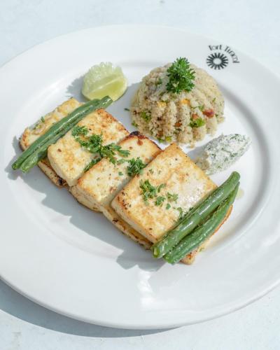 a white plate of food with fish and asparagus at Fort Tiracol Goa in Arambol