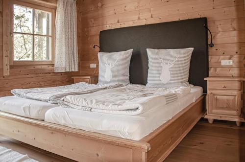 a bedroom with a large bed in a log cabin at Quartier360Grad in Bolsterlang