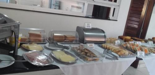 a buffet with different types of food on a table at Areia Branca Apart Hotel in Areia Branca