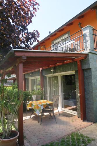 a patio with a table and chairs in front of a house at Gránit Villa in Balatonszárszó
