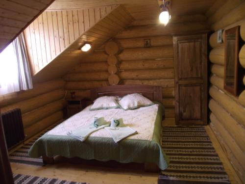 a bedroom with a bed in a log cabin at Cabana Piatra Runcului in Vatra Moldoviţei