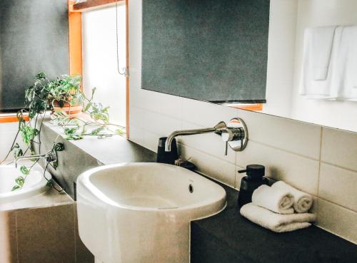 a bathroom with a sink and a mirror at Byron Butter Factory Apartments in Byron Bay