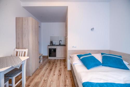 a bedroom with a bed with blue pillows on it at Purtulka pokoje klimatyzowane in Pobierowo