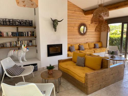 a living room with a yellow couch and a fireplace at Le Mas de Cocagne in Saintes-Maries-de-la-Mer