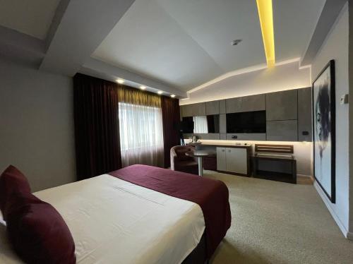 a hotel room with a bed and a kitchen at Queen's Hotel - Zebra Centre in Skopje