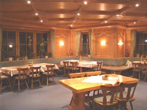 una sala da pranzo con tavoli e sedie in legno di Bäuerlehof a Seebach