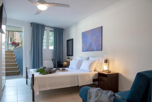 a bedroom with a white bed and a chair at Villa Kallisti in Iraklitsa