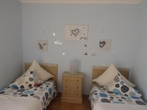 2 Betten in einem Zimmer mit Bildern an der Wand in der Unterkunft Ferienhaus Casa Yelmo in Cala Mendia