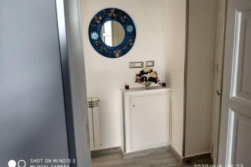Zimmer mit einem Spiegel und einem Tisch mit Blumen in der Unterkunft Home sweet home appartamento ricco di comfort in Palermo