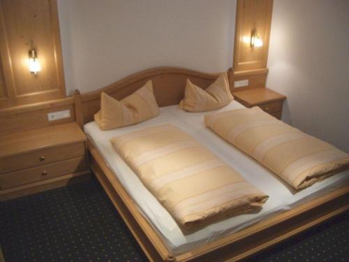 a large bed in a room with two night stands at Bäuerlehof in Seebach