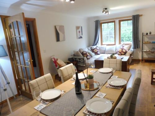 a living room with a table and a couch at The Nook Holiday Cottage in Aviemore