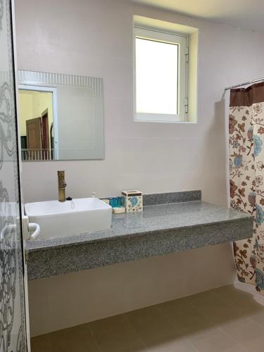 a bathroom with a sink and a mirror at Oriental Nights Rest House in Al Wāşil
