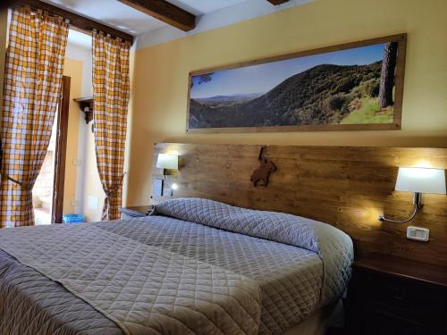 a bedroom with a bed and a tv on the wall at Locanda Mossa Dei Barbari in Buriano