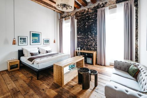 a living room with a bed and a couch at Boutique hotel Corso in Řevnice