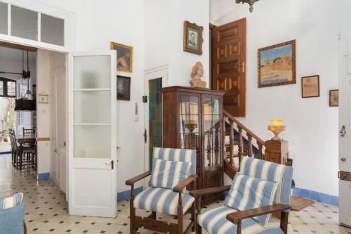 a living room with two chairs and a staircase at Hauzify I Casa Colonial in San Pol de Mar