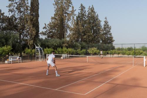 two people playing tennis on a tennis court at The Oberoi Marrakech in Marrakech