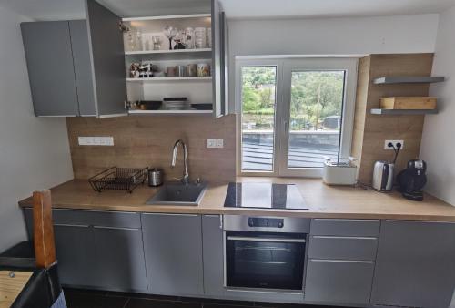 a kitchen with a counter and a sink and a window at Badacsonyi rege in Badacsonytördemic