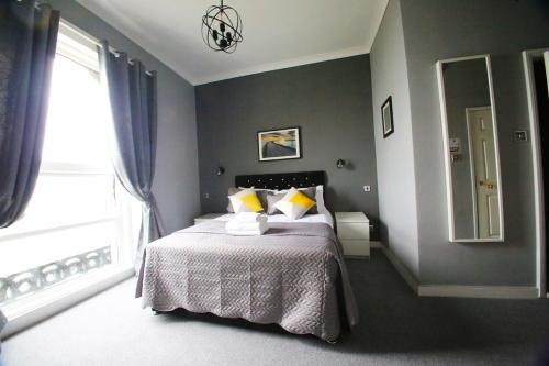 a bedroom with a bed and a large window at The Lansdowne in Hastings