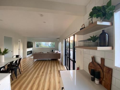 a kitchen and living room with a table and chairs at Waikanae Beach Abode in Waikanae