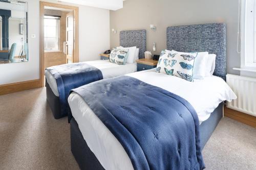 a hotel room with two beds and two night stands at Ennios Boutique Hotel in Southampton