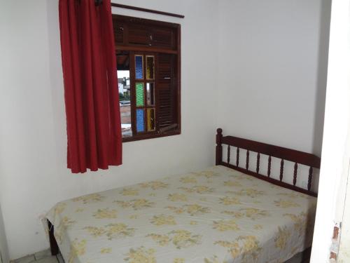 1 dormitorio con cama y ventana en Condomínio Mar Azul, en Salvador