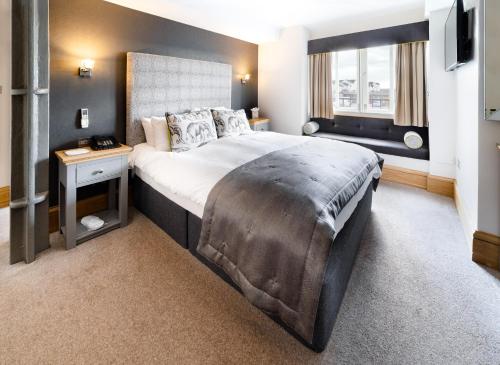 a bedroom with a large bed and a window at Ennios Boutique Hotel in Southampton