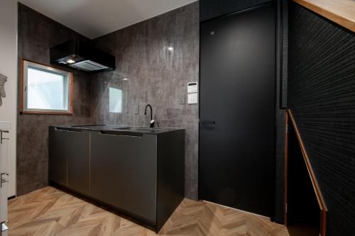 a kitchen with a black counter and a sink at Oyado Urushi / Vacation STAY 50682 in Nagasaki