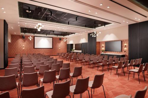a large room with rows of chairs and screens at Malmaison York in York