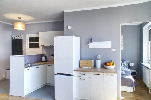 uma cozinha com armários brancos e um frigorífico branco em M&S Apartament em Świnoujście