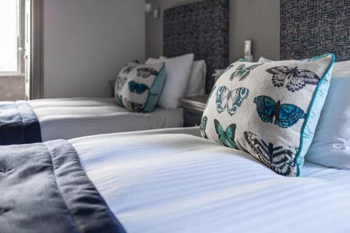 a bedroom with two beds with blue and white pillows at Ennios Boutique Hotel in Southampton