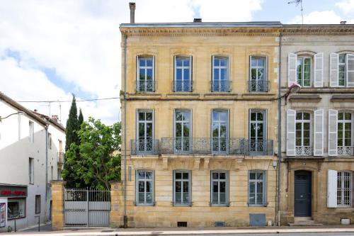 an old brick building with windows and a blue door at B&B Le Clos d'Argenson in Bergerac