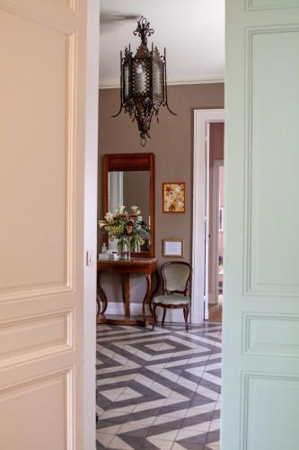 a hallway with a table and a chair and a mirror at B&B Le Clos d'Argenson in Bergerac