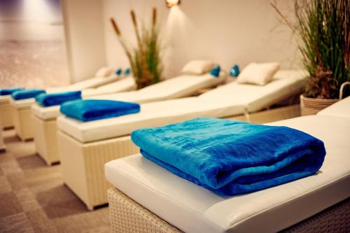 a row of white couches with blue pillows on them at DJH Resort Neuharlingersiel in Neuharlingersiel