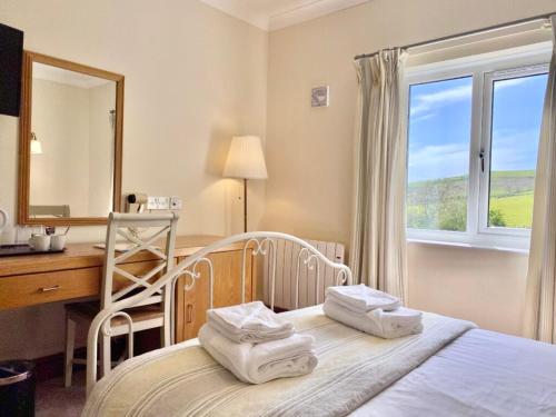 um quarto com uma cama, uma secretária e um espelho. em Llety Ceiro Guesthouse em Aberystwyth