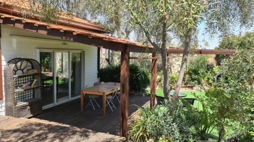 a wooden pergola on a deck with a table at Olives in Arad