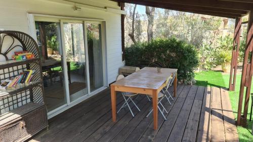 a wooden deck with a table on a house at Olives in Arad