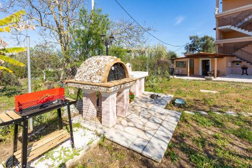 a backyard with a brick oven in a yard at Aloe Seaview Apartments by Konnect, 500m from Dassia Beach in Dassia