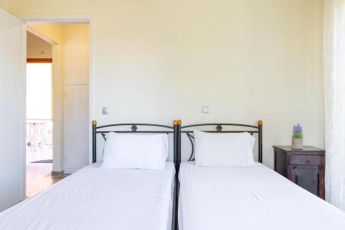 a bedroom with two beds with white sheets at Aloe Seaview Apartments by Konnect, 500m from Dassia Beach in Dassia