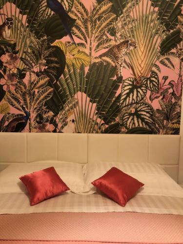 1 cama con 2 almohadas rojas frente a una pared en Grazia's Apartment, en Chioggia
