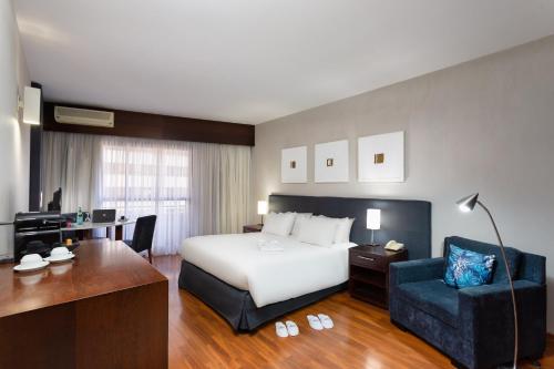 een hotelkamer met een bed en een bureau bij Mercure Sao Paulo Grand Plaza Paulista in Sao Paulo