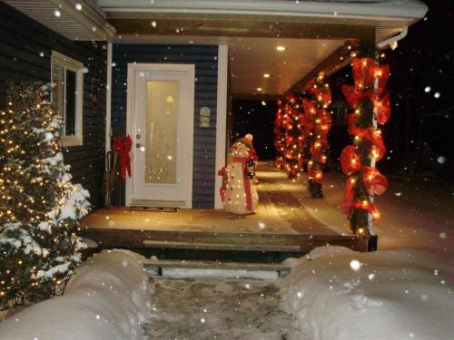 una casa con adornos de Navidad en el porche delantero en La Petite Douceur en Lac-Superieur